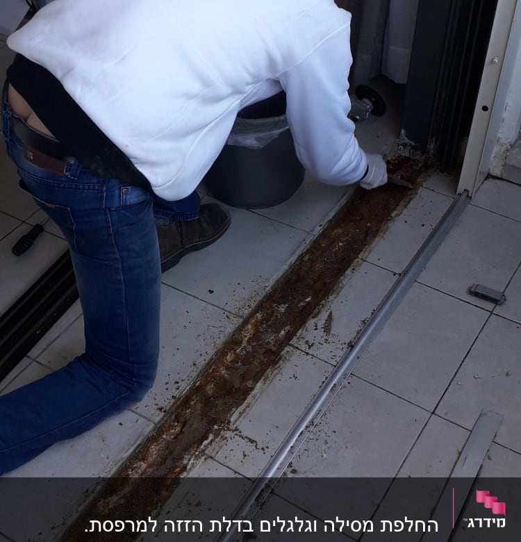 עובד מתקין מסילת אלומיניום על רצפה